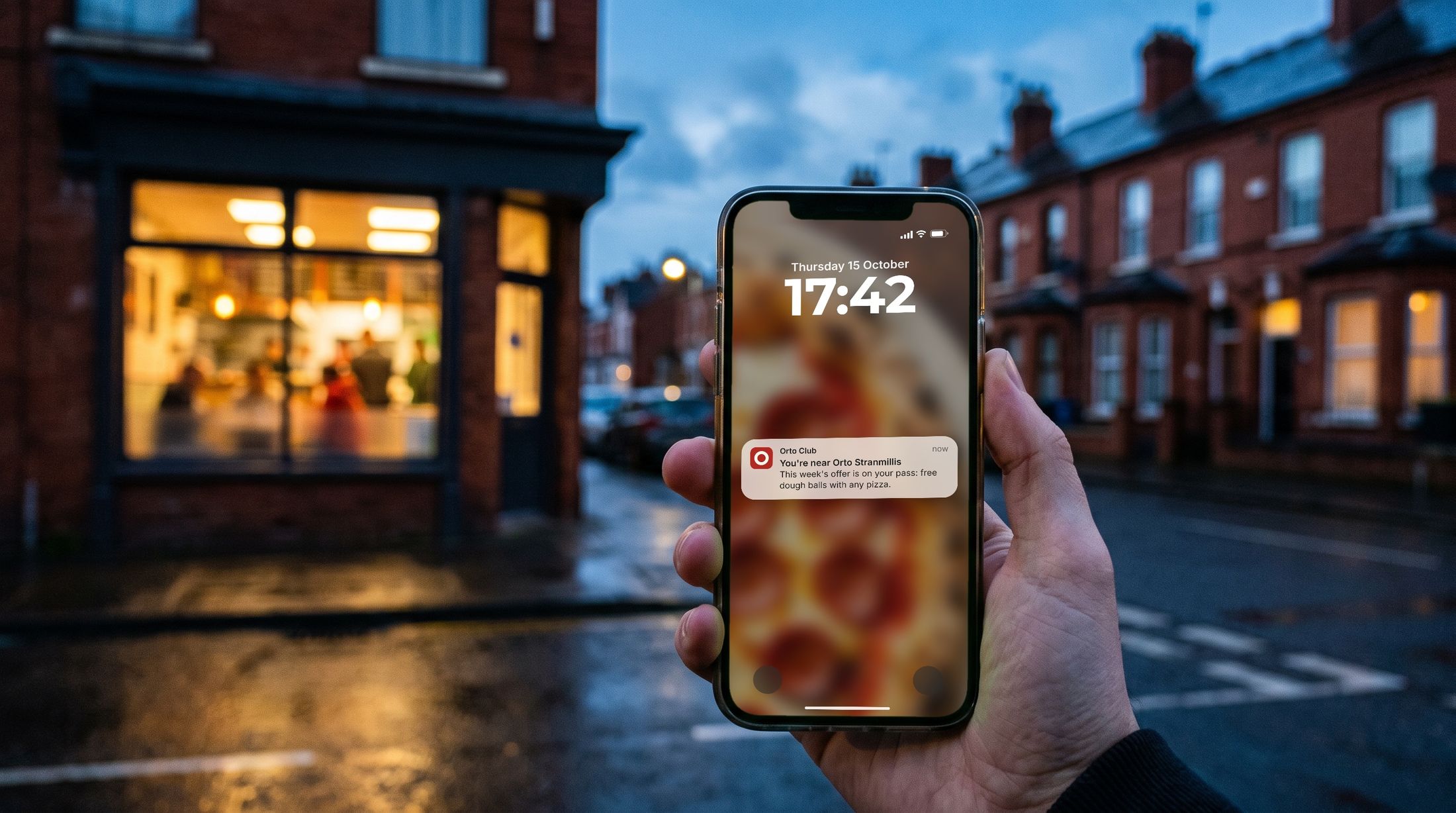A member on a Belfast street at dusk sees an Orto Club notification on their lock screen